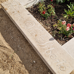 Sculpteur de pierre professionnel réalisant un monument funéraire personnalisé